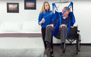 healthcare professional assisting man in a ceiling lift