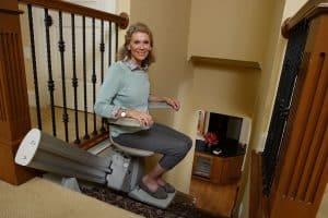 Senior woman smiling while seated stair lift