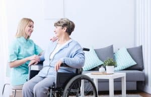 Senior woman on wheelchair and her caregiver