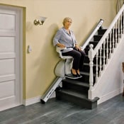 Senior woman using stair lift in middle of stair