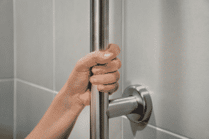 woman's hand holding grab bars in bathroom