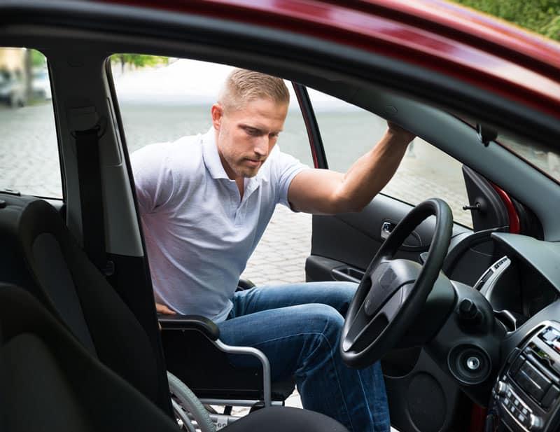 man on wheelchair entering car