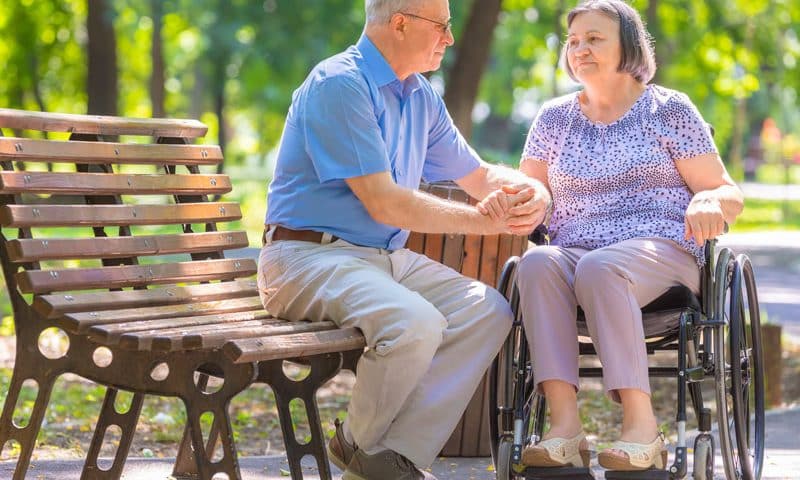 couple at the park. woman on wheelchair