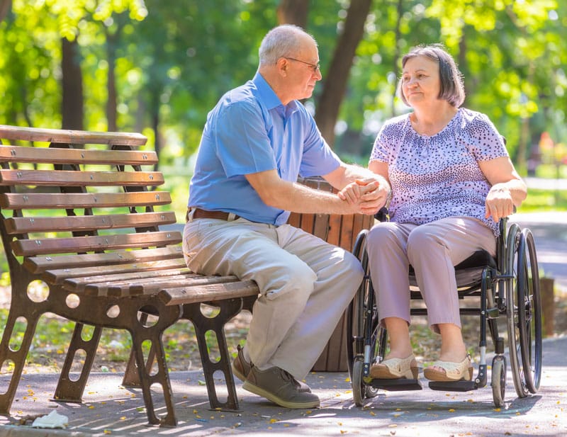 couple at the park. woman on wheelchair