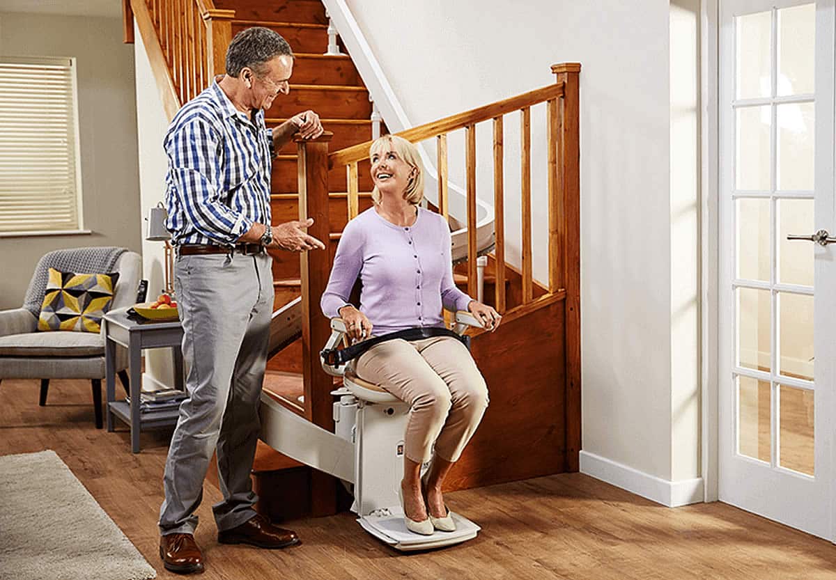 Couple talking next to a power stair lift