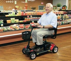 Man in super market riding a 4 wheeled scooter