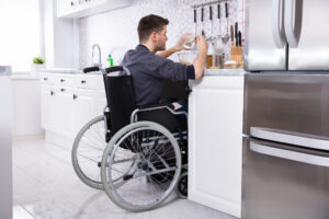 Disabled Man Preparing Food In Kitchen